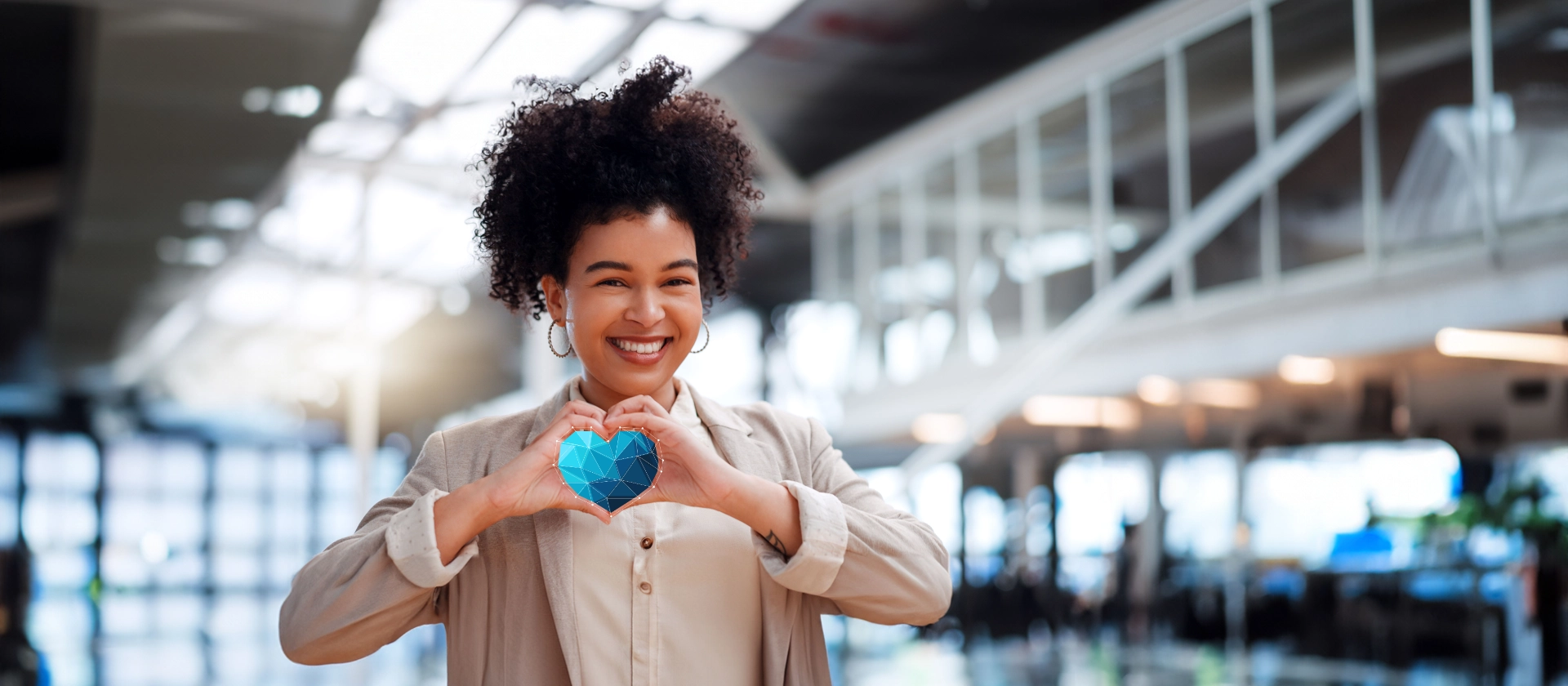 Frau in Anzug formt Herz-Zeichen mit den Händen