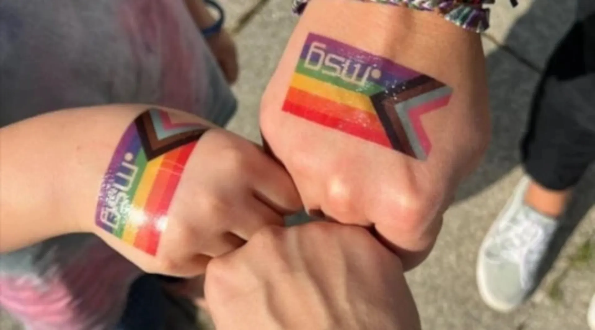 Handrücken mehrerer msg-Kolleginnen und Kollegen mit temporären Regenbogen-Tattoos