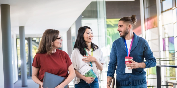 Eine gemischte Gruppe von msg-Mitarbeitenden in einem hellen Korridor am msg-Standort Ismaning
