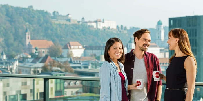 eine gemischte Gruppe von msg-Kollegen genießen eine Pause auf der Dachterrasse von msg in Passau