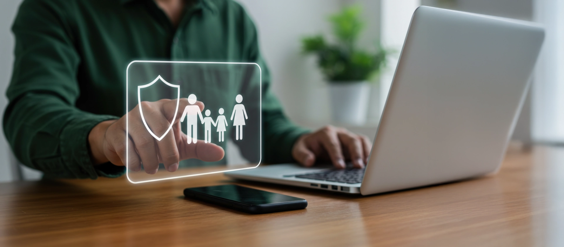 Ein mittelalter Mann interagiert mit einem digitalen Bildschirm, der Symbole für Familienschutz darstellt, während er an einem Laptop an einem Holztisch arbeitet und ein Smartphone in der Nähe liegt.